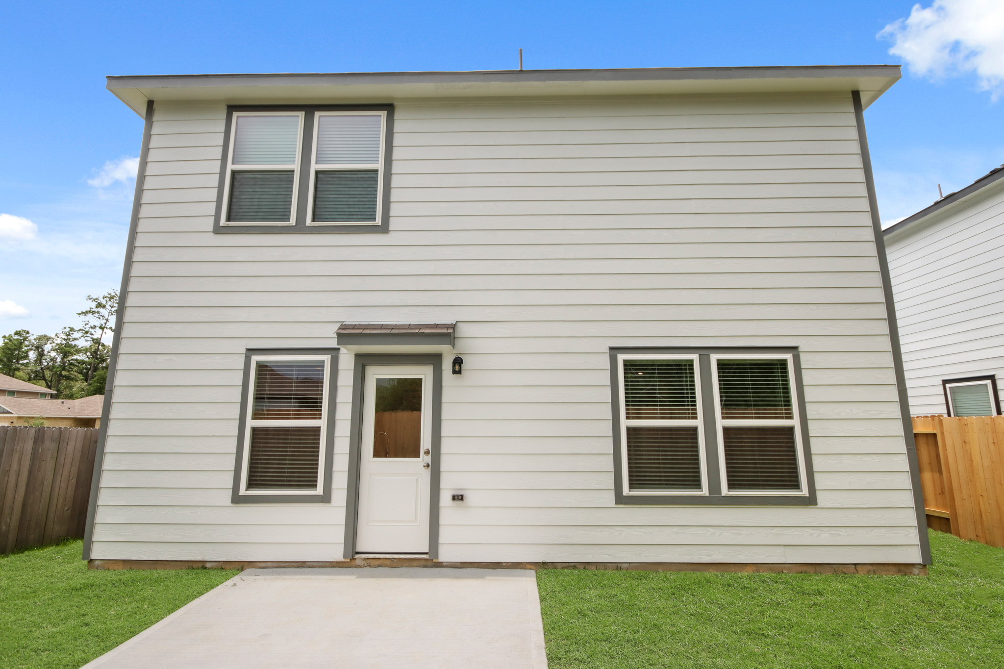 A white house with a green lawn.