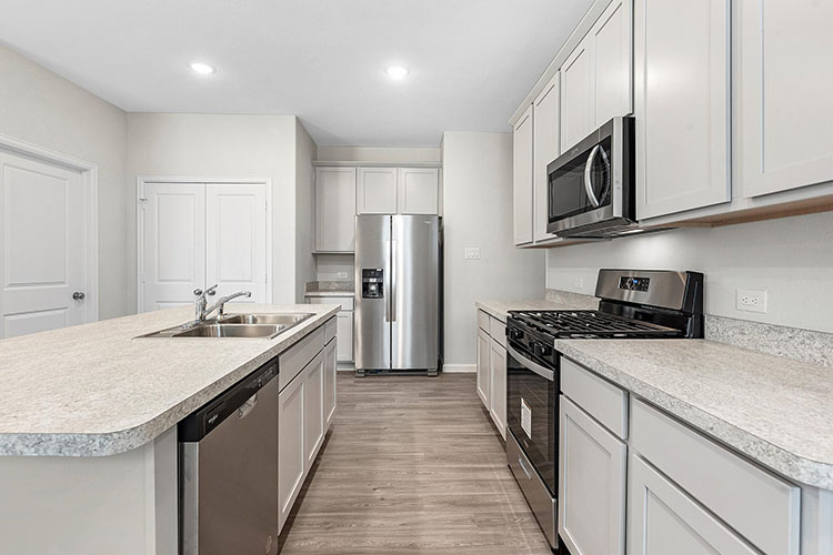 A kitchen with white cabinets.