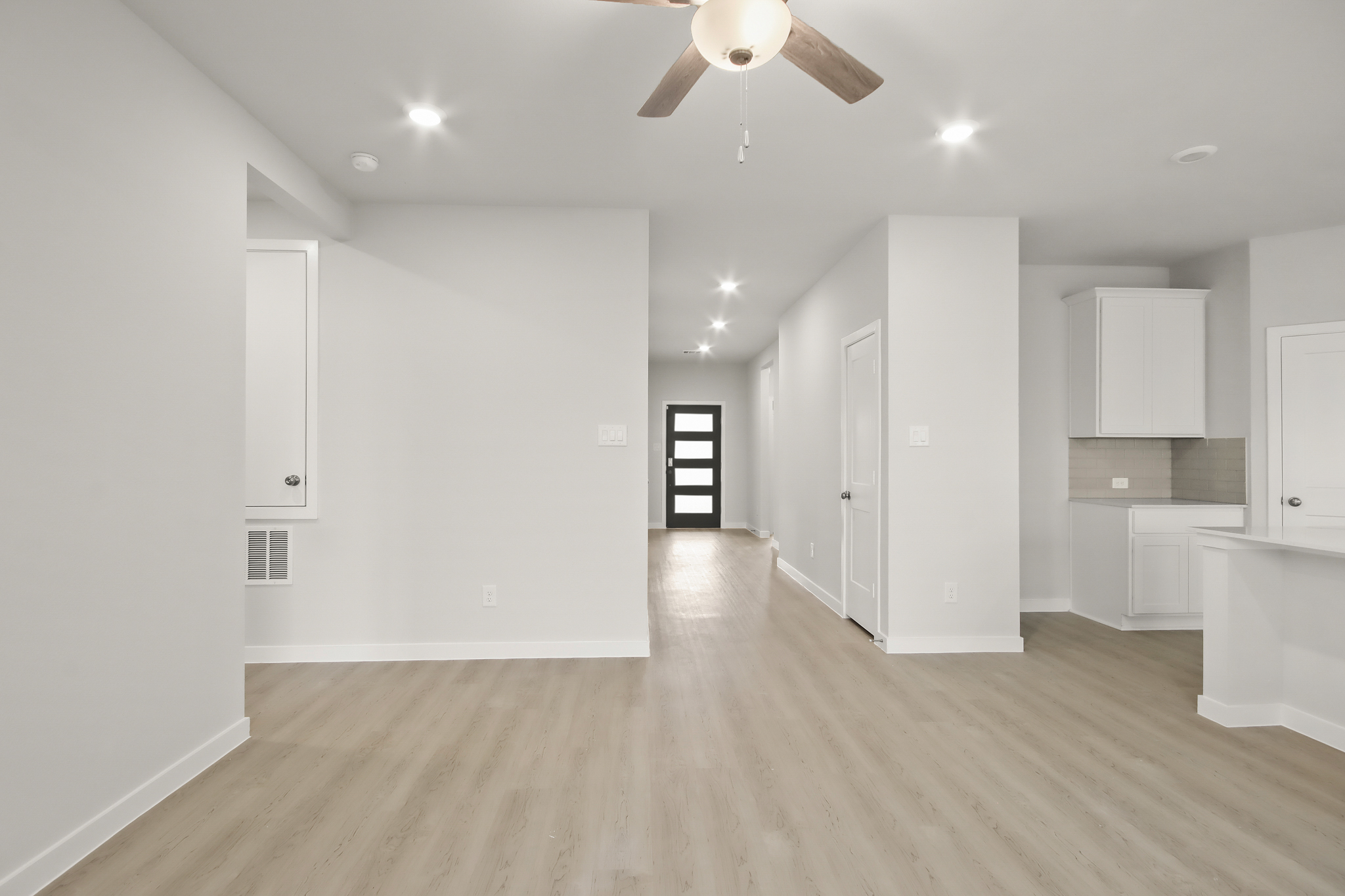 A room with white cabinets and a ceiling fan.