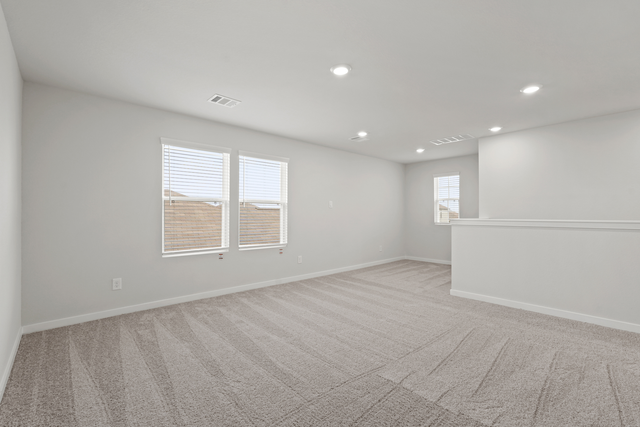 A room with a carpet and windows.