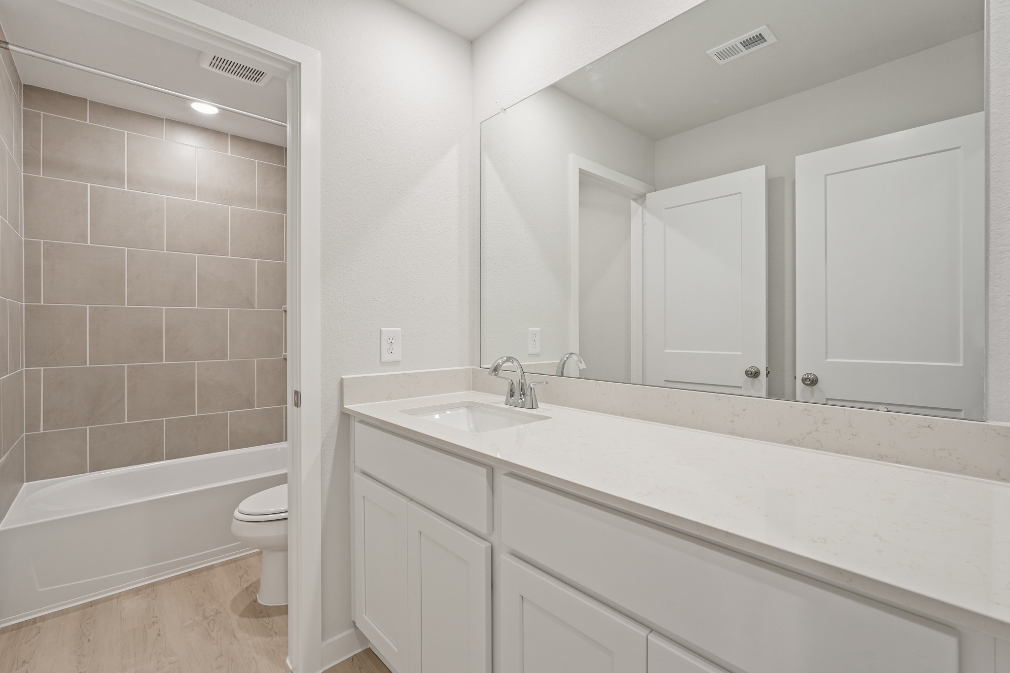 A bathroom with a tub sink and toilet.
