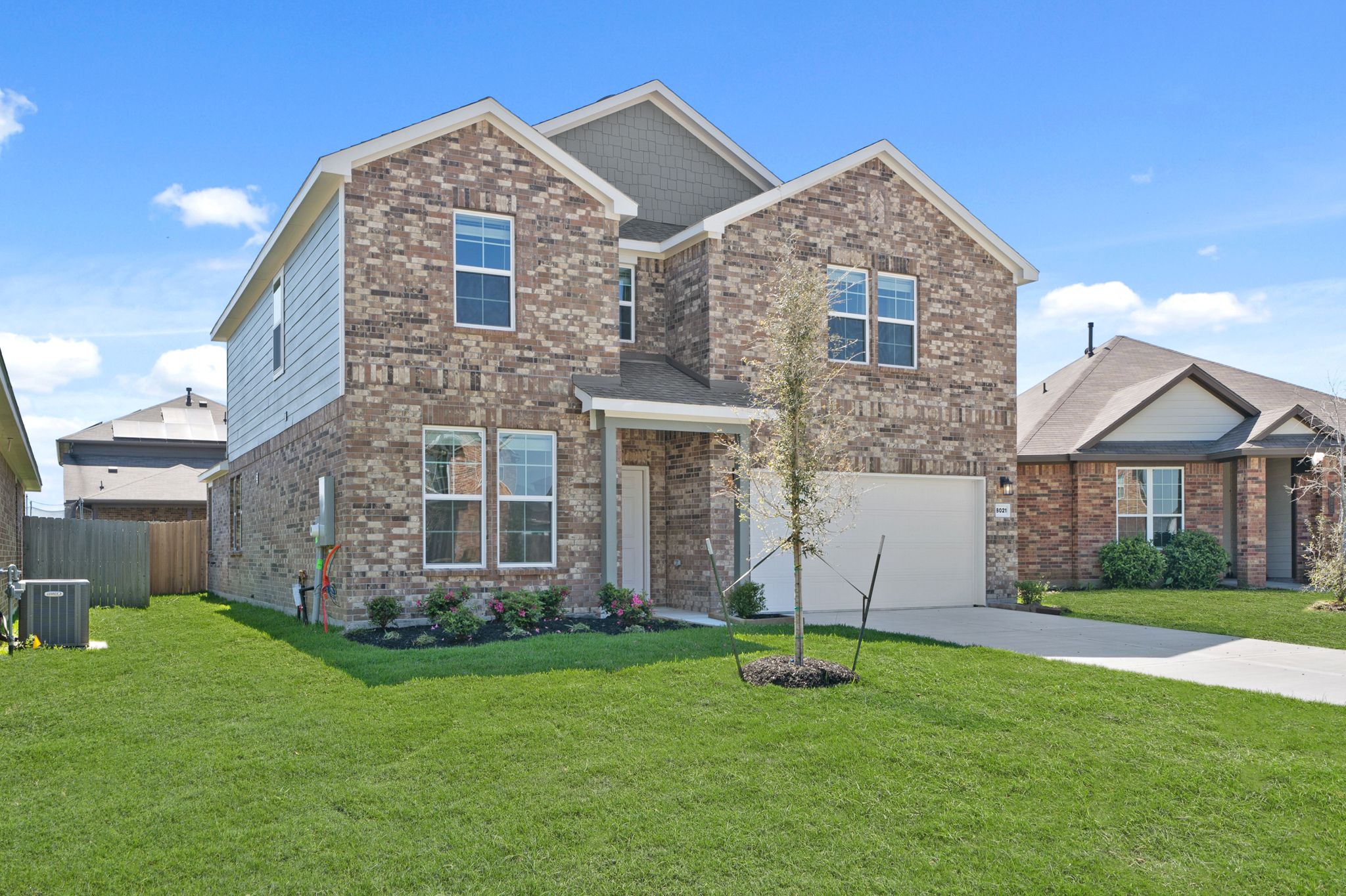 A brick house with a green lawn.