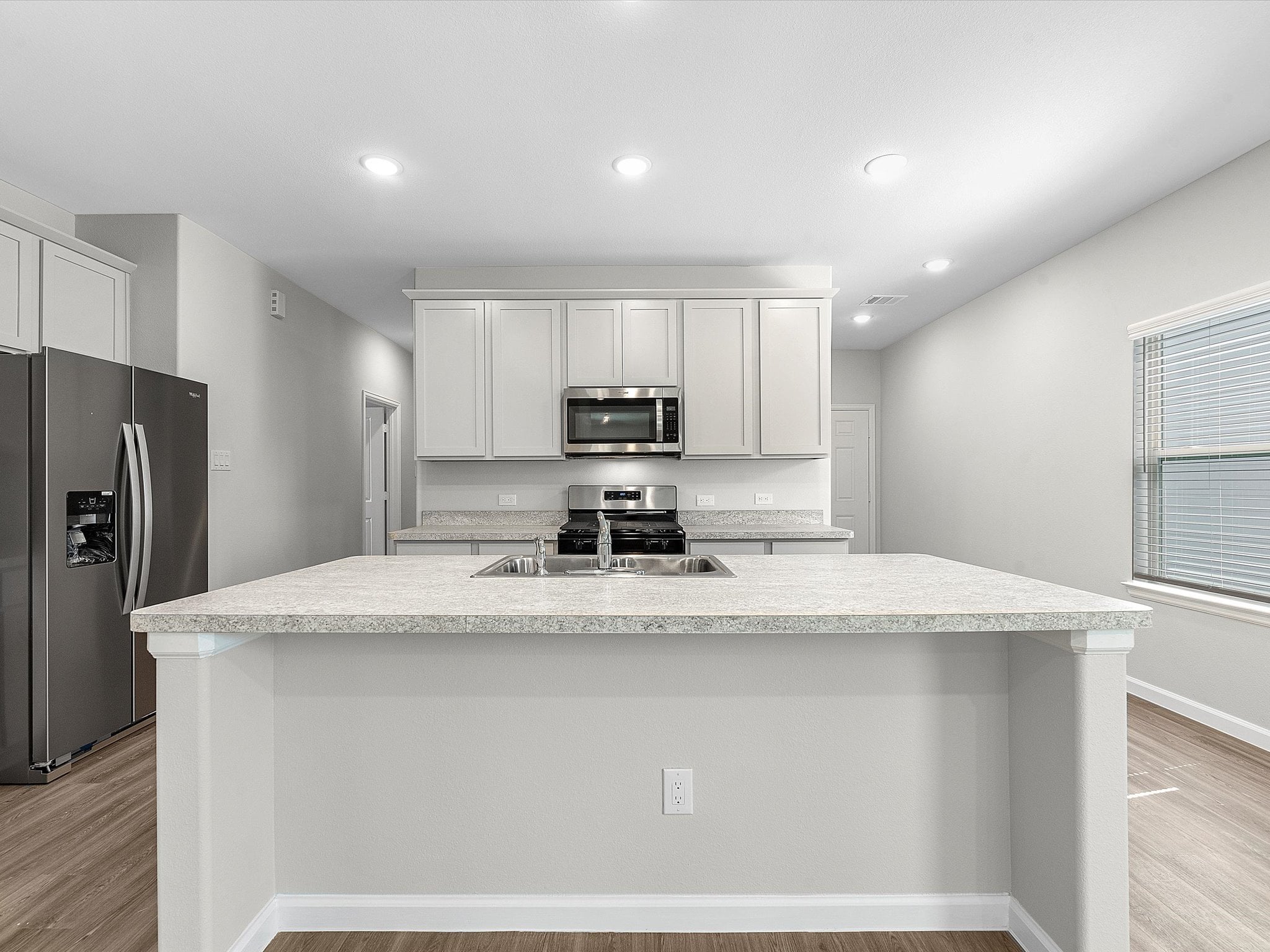 A kitchen with white cabinets.