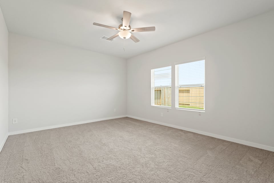 A room with a ceiling fan and a window.