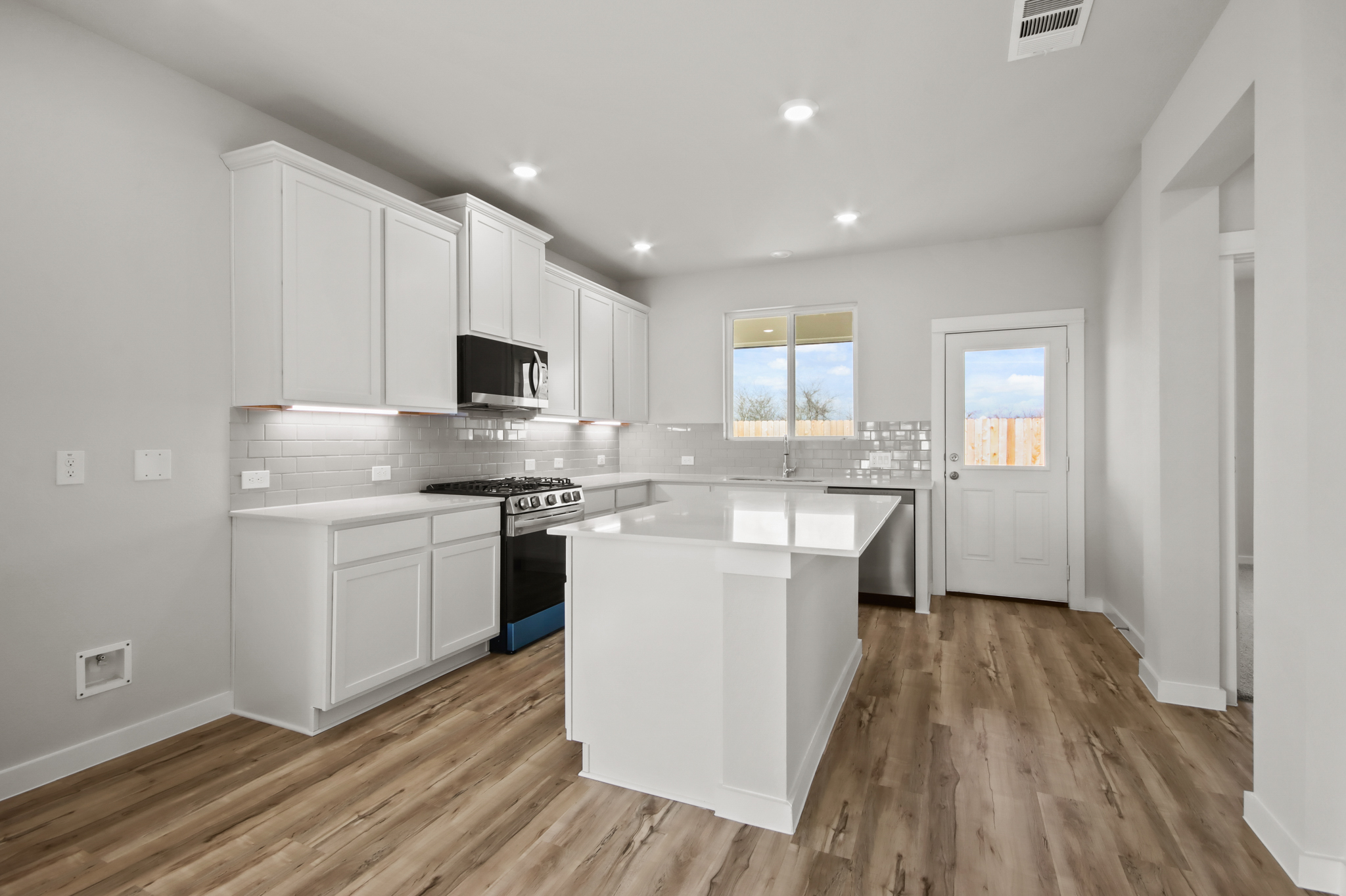 A kitchen with white cabinets.