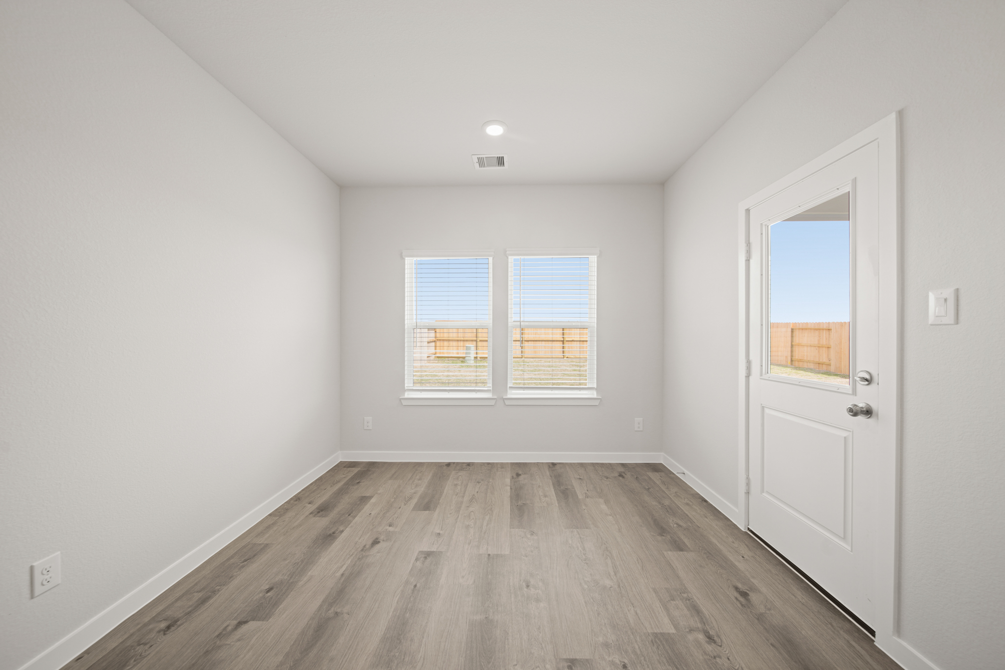A room with a wood floor and a white door.