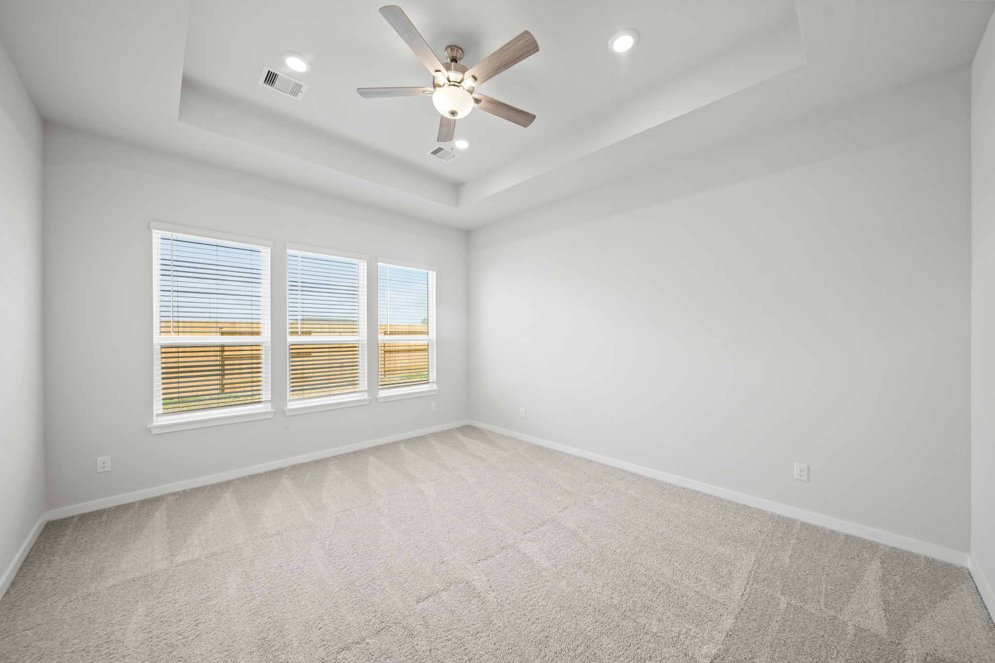A room with a ceiling fan and a window.