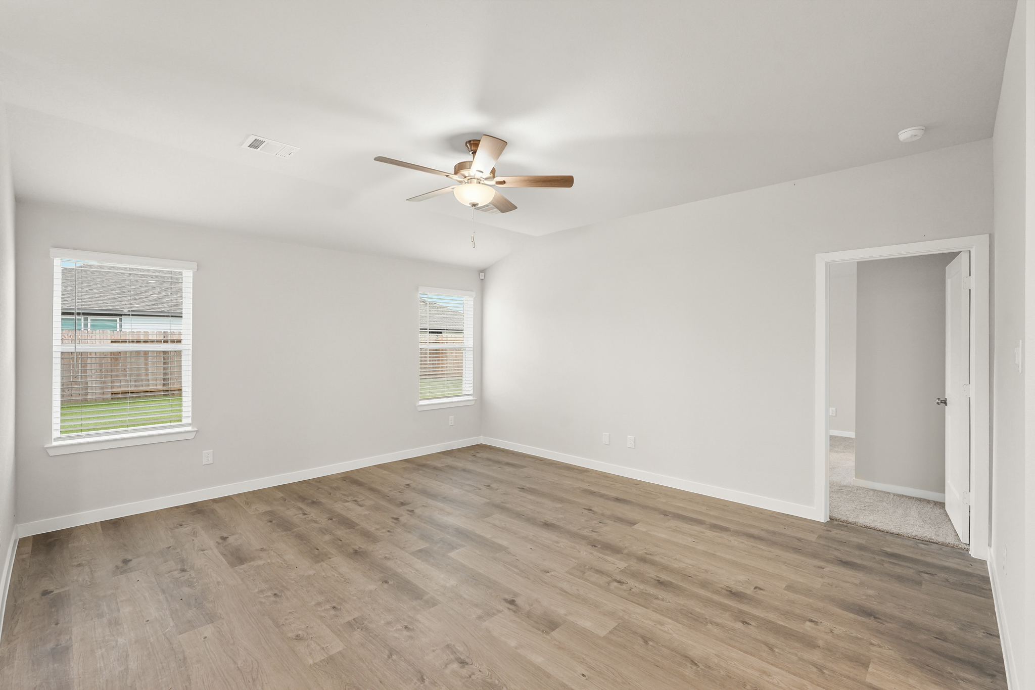 A room with a wood floor and a ceiling fan.