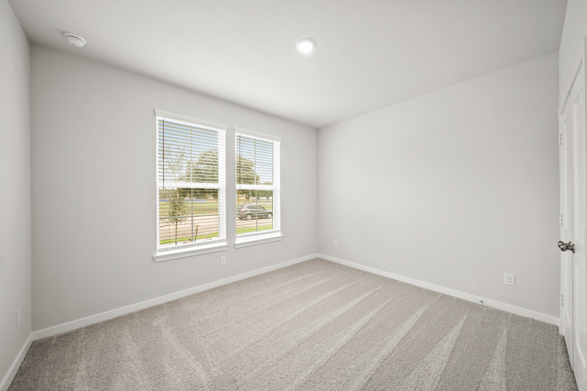A room with a window and a rug.