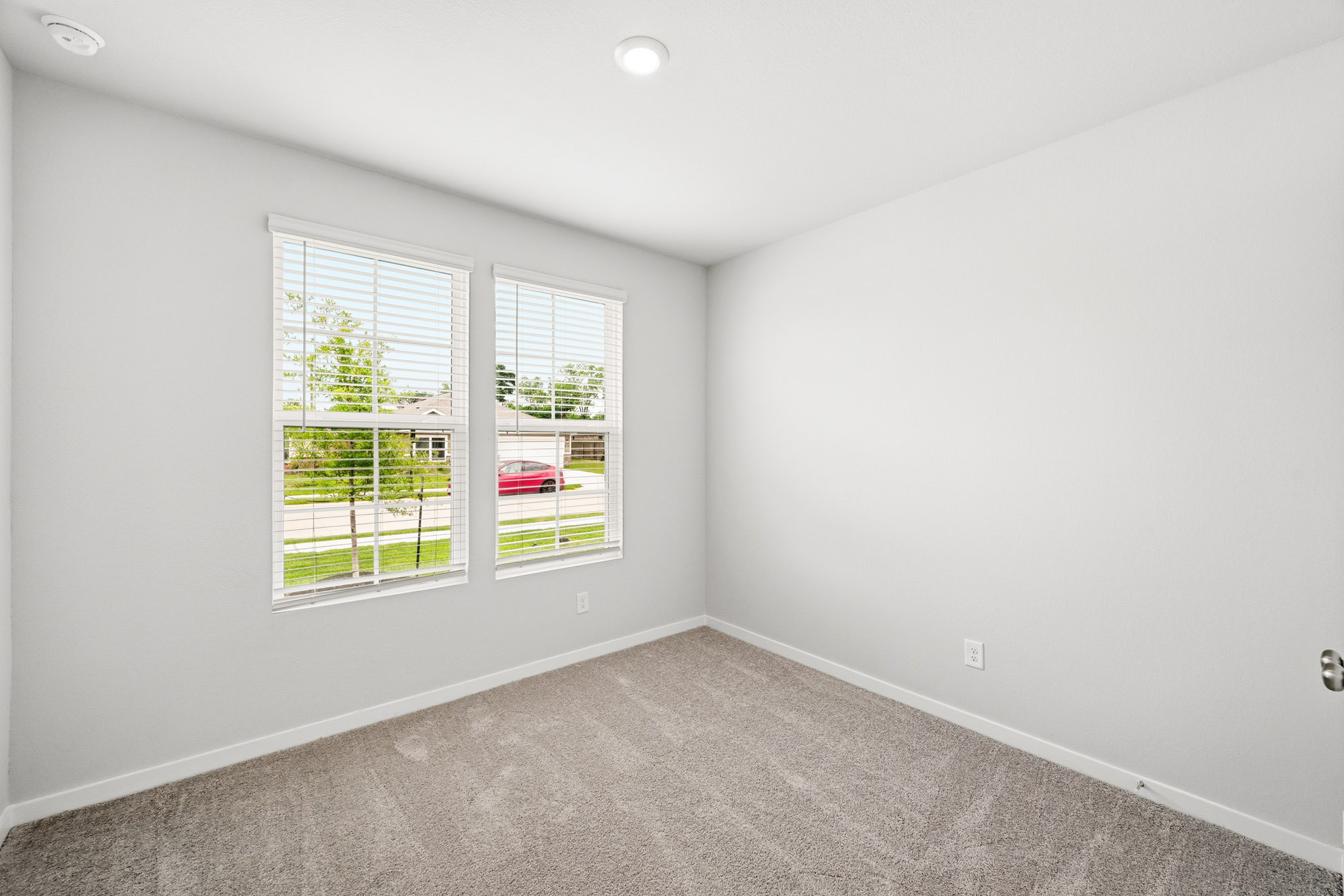 A room with a window and a carpet.