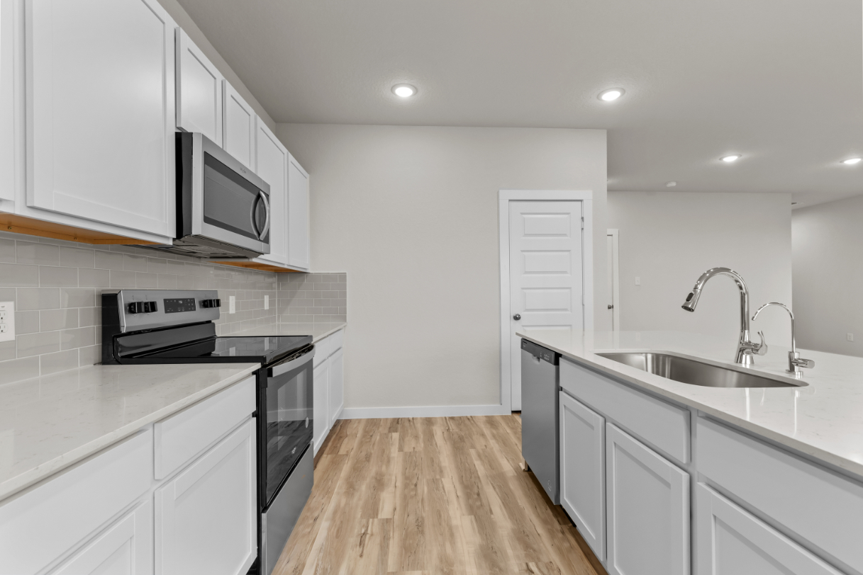 A kitchen with white cabinets.