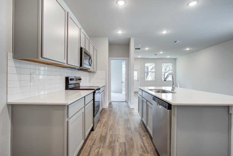 A kitchen with white cabinets.