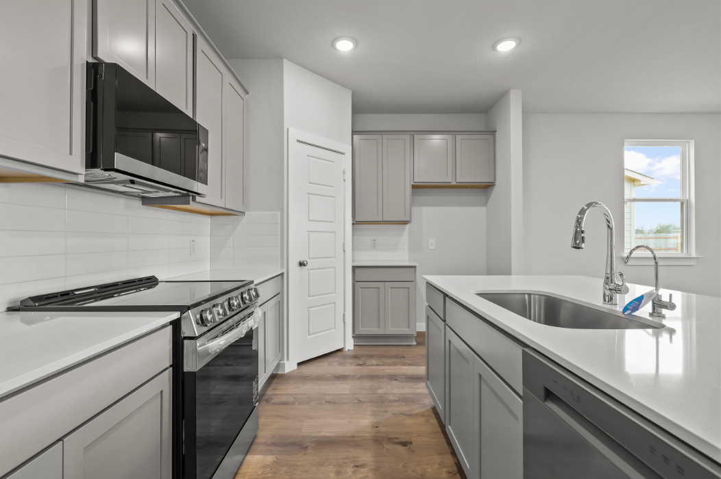 A kitchen with white cabinets.