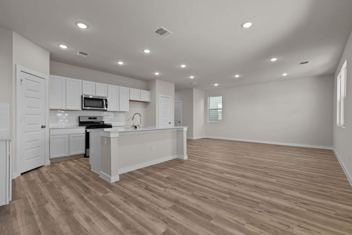 A kitchen with white cabinets.