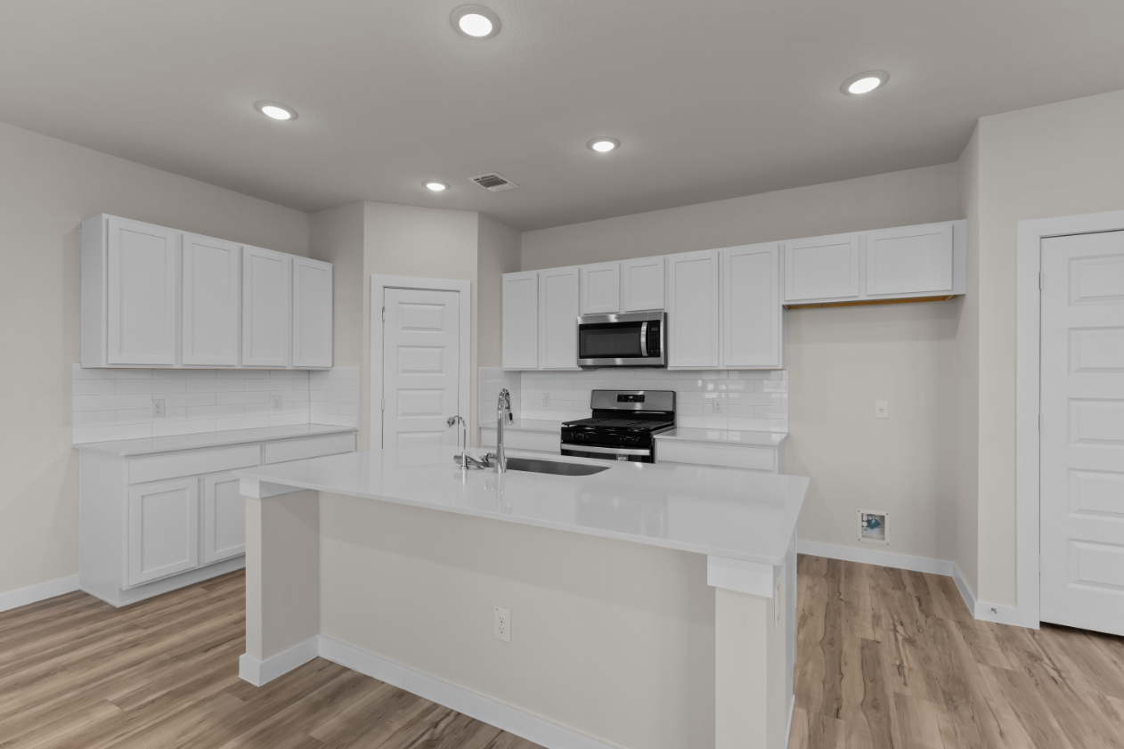 A kitchen with white cabinets.