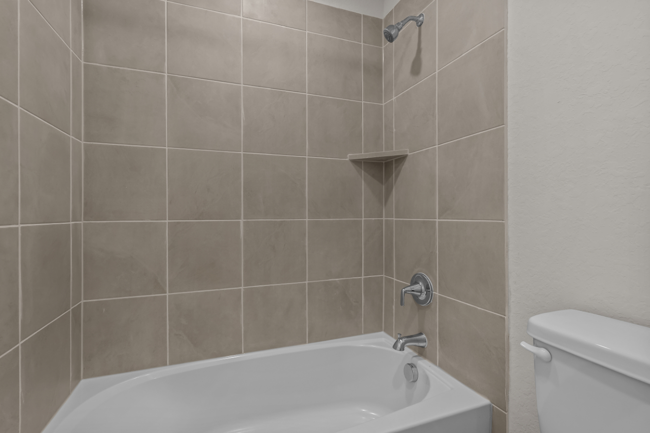 A bathroom with a bathtub and toilet.