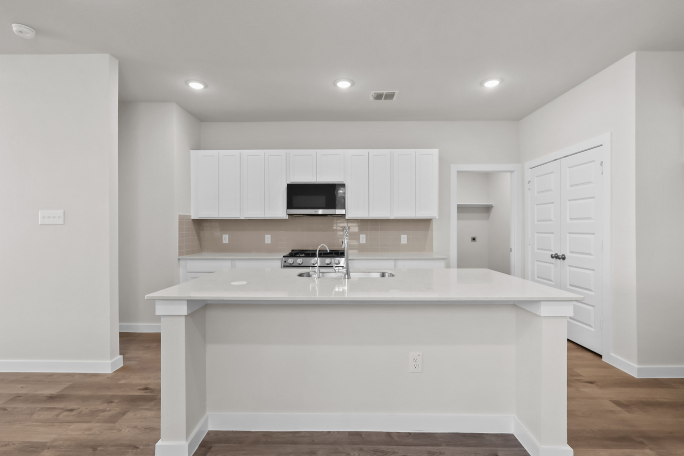A kitchen with white cabinets.