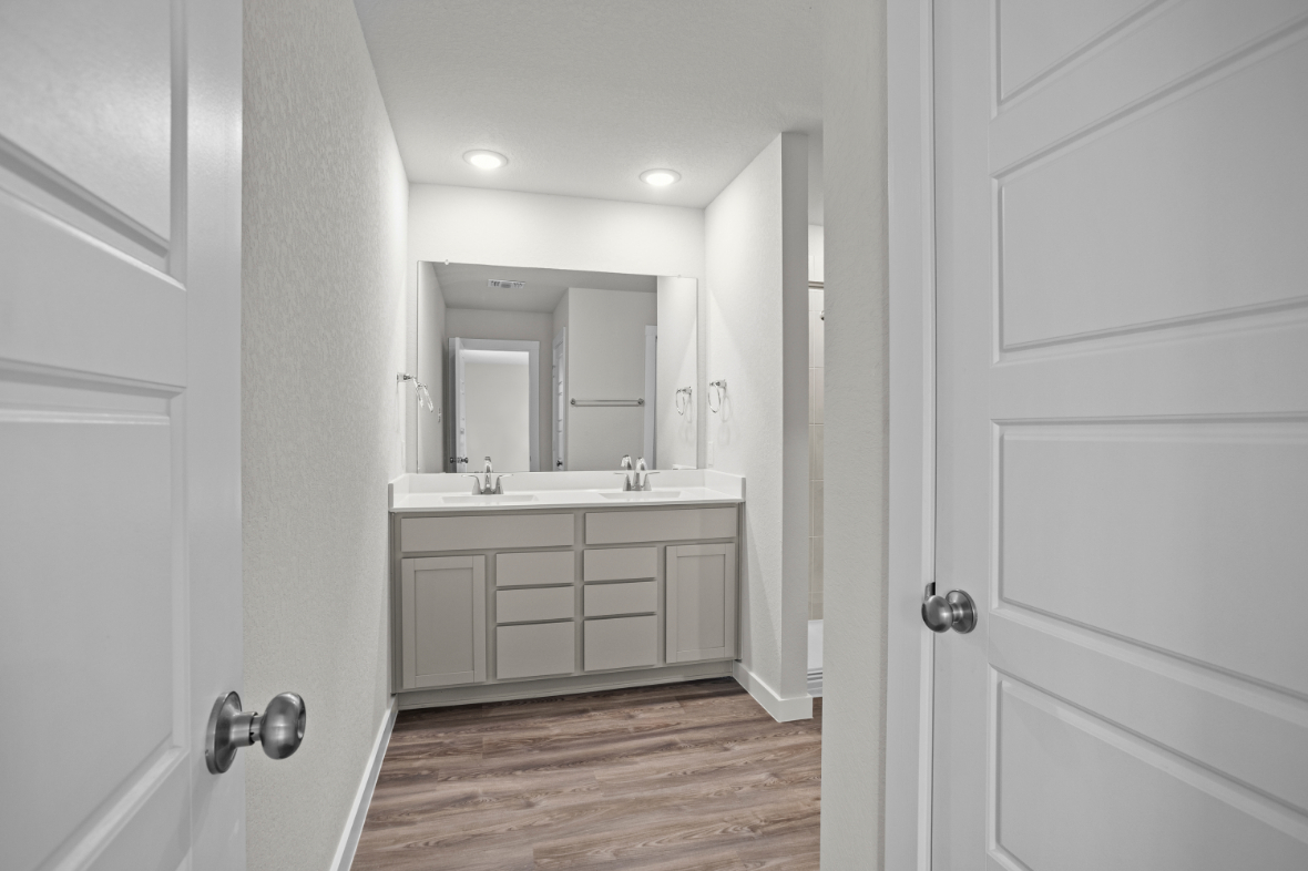 A bathroom with white cabinets.