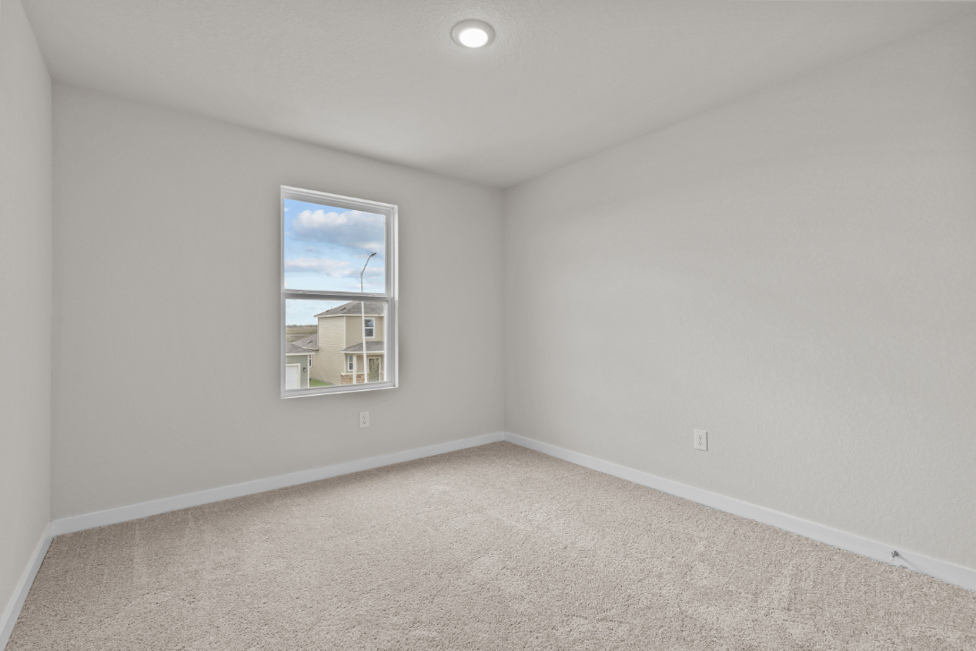 A room with a window and a carpet.