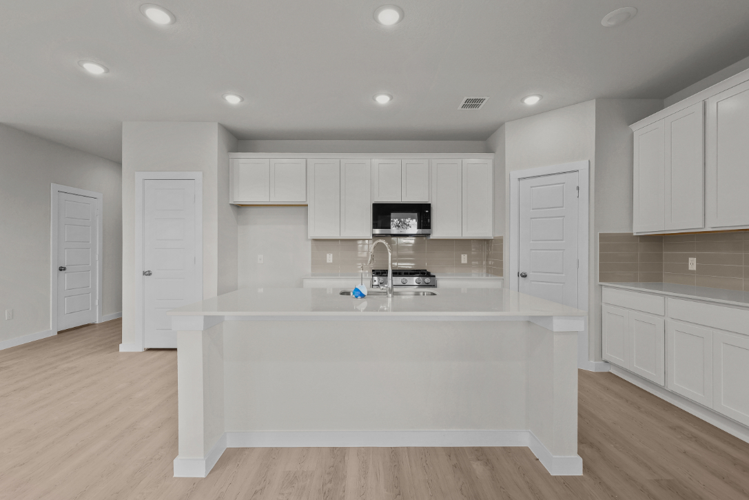 A kitchen with white cabinets.