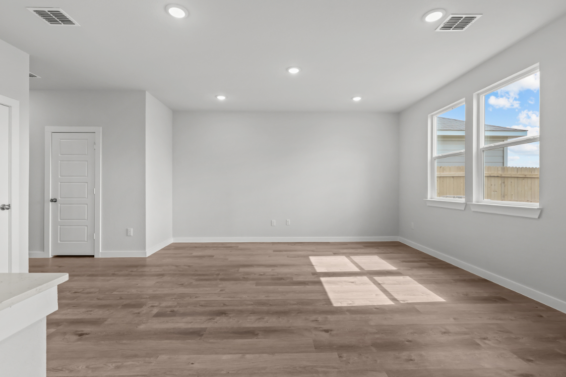 A room with a wood floor and white walls.