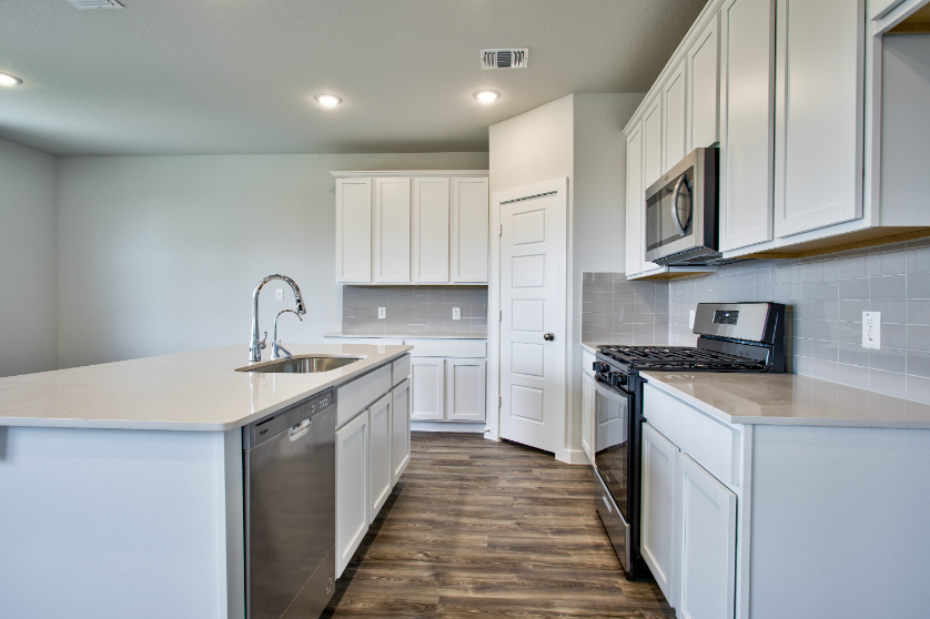A kitchen with white cabinets.