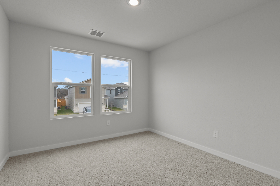 A room with a window and a carpet.