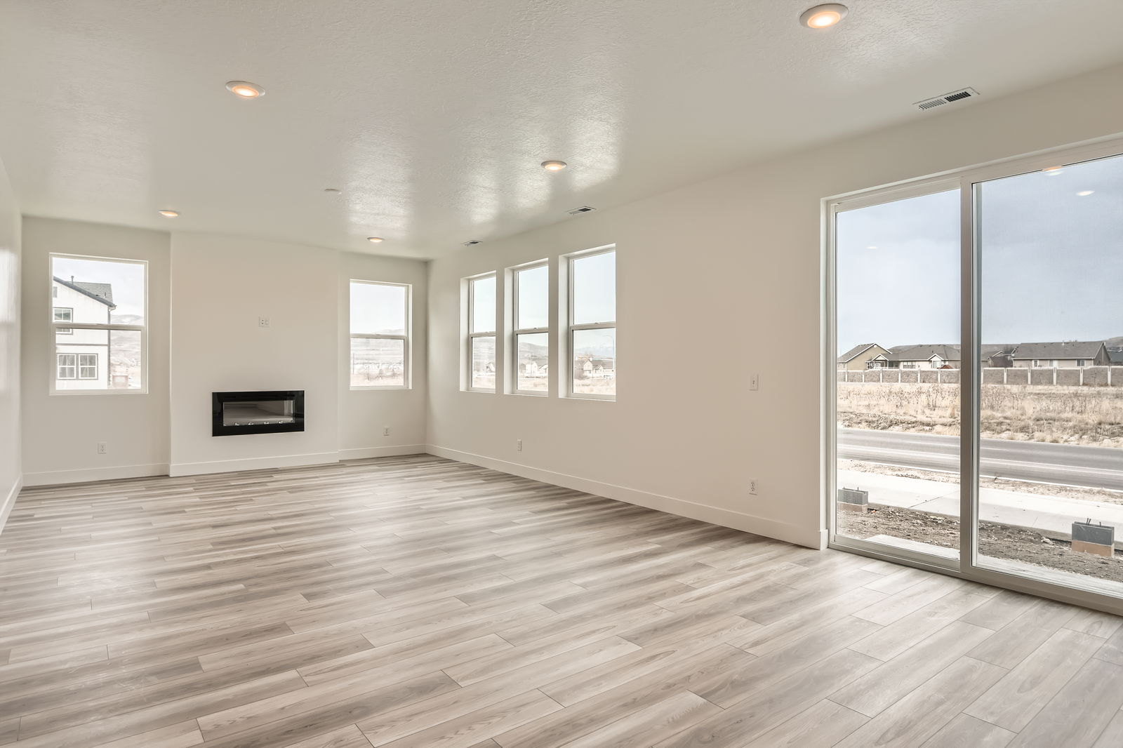 A room with windows and a wood floor.
