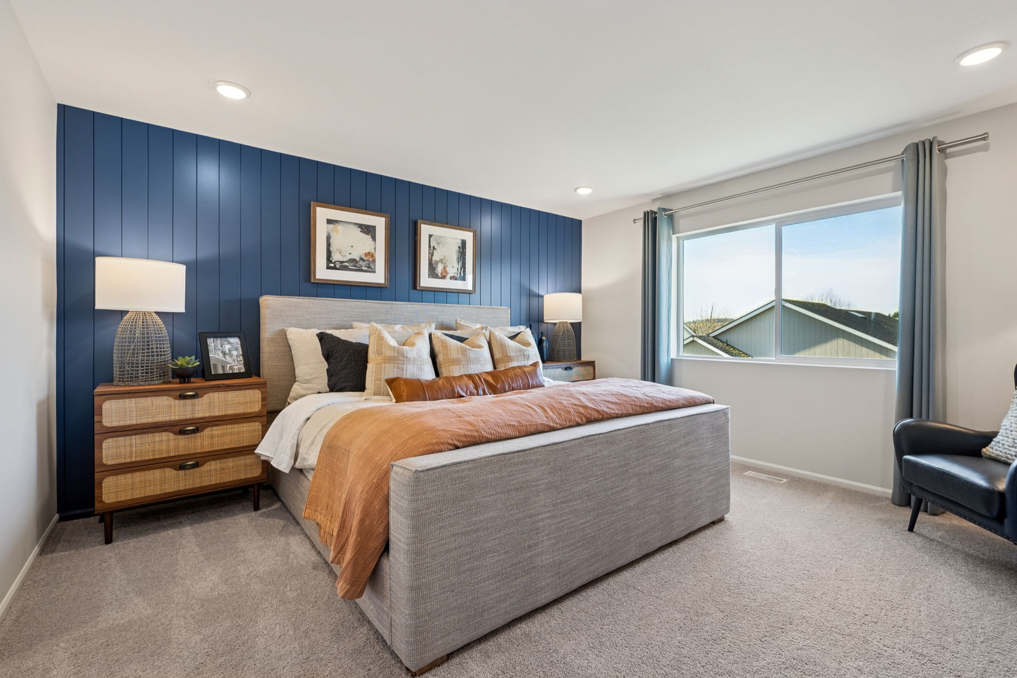 A bedroom with a bed and a chair.