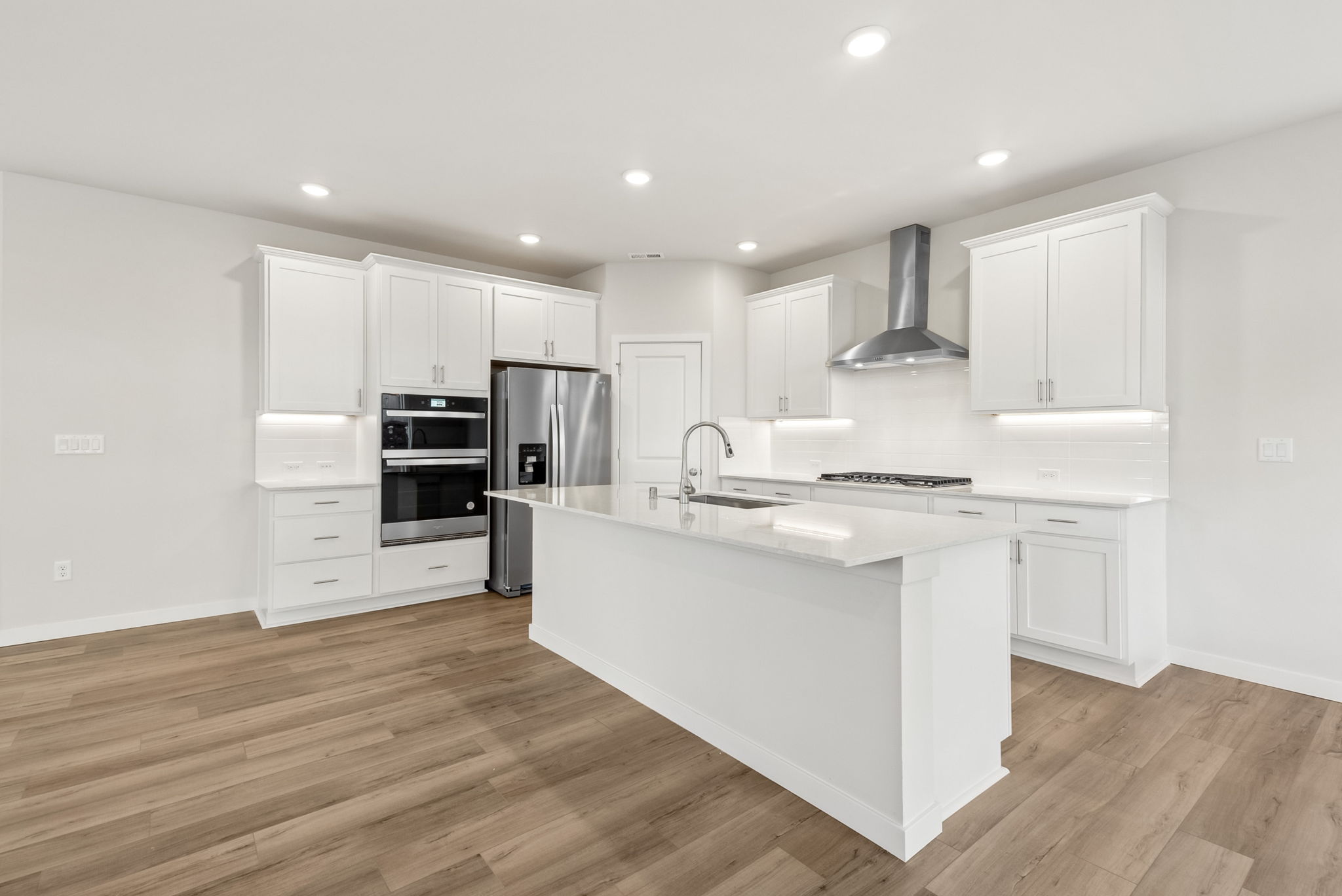 A kitchen with white cabinets.