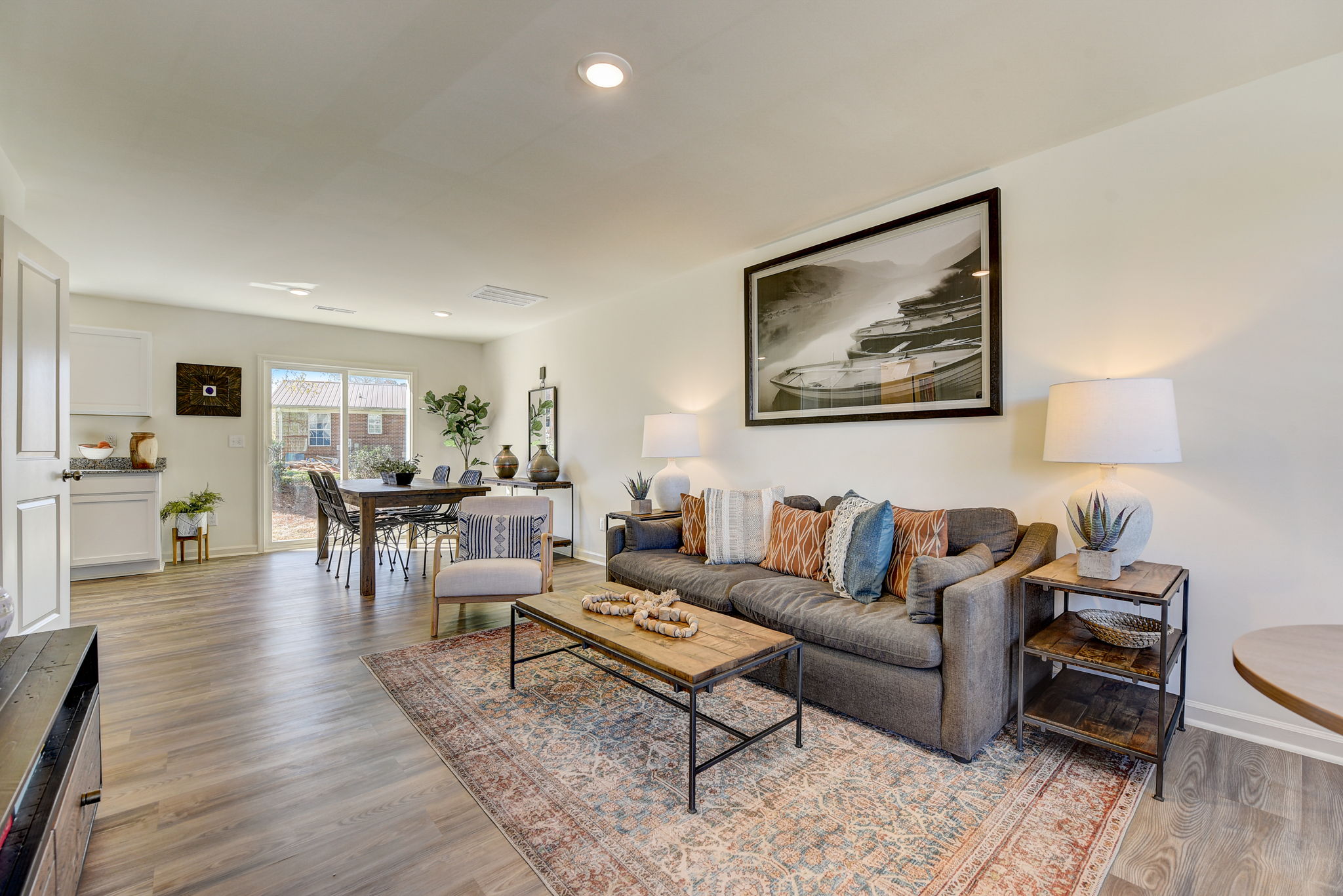 A living room with a large rug and a wood floor.