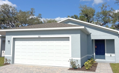 A white garage with a blue door.