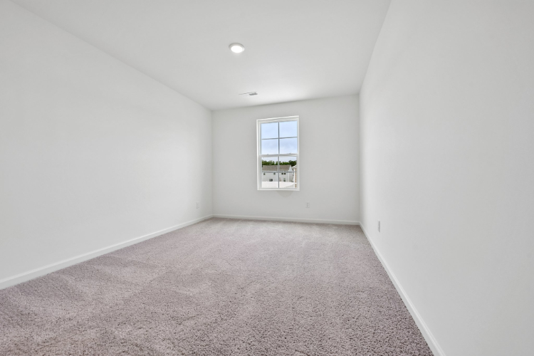 A room with a window and carpet.