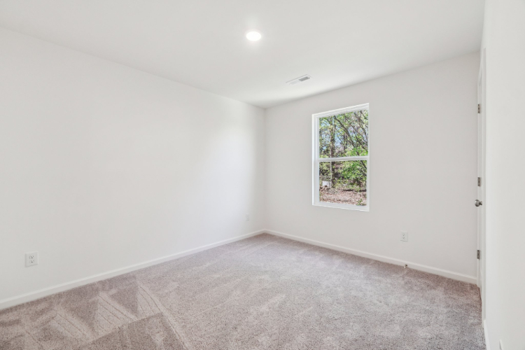 A room with a window and carpet.