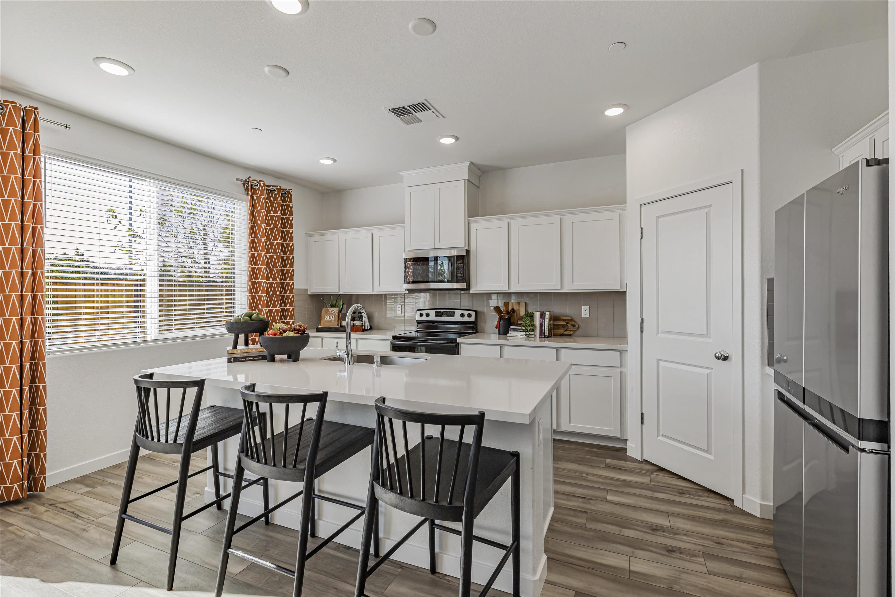 A kitchen with white cabinets.